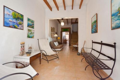 a living room with chairs and paintings on the walls at Ca na Miquela in El Arenal