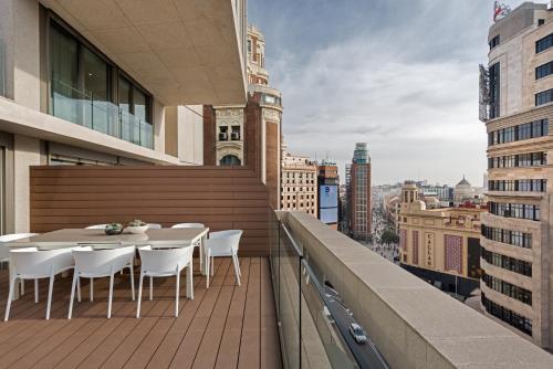 a balcony with a table and chairs on a building at Gran View Apartments in Madrid