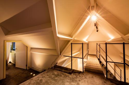 a room with stairs and a light on the ceiling at Landgoed Kasteel de Hoogenweerth in Maastricht