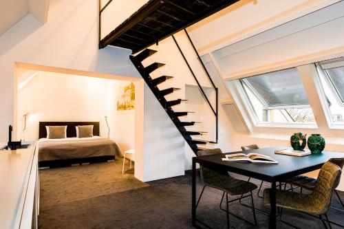 a room with a bed and a table and a spiral staircase at Landgoed Kasteel de Hoogenweerth in Maastricht