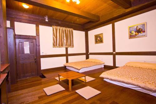 a room with two beds and a table at Maple Leave Holiday Villa in Renai