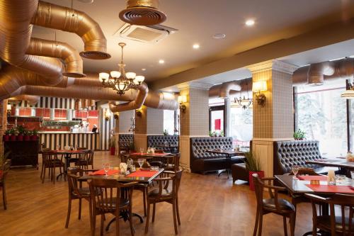 une salle à manger avec des tables et des chaises dans un restaurant dans l'établissement Eurootel Stavropol, à Stavropol