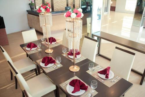 a table with chairs and a table with red napkins at Casablanca Suites Near Airport in Legazpi