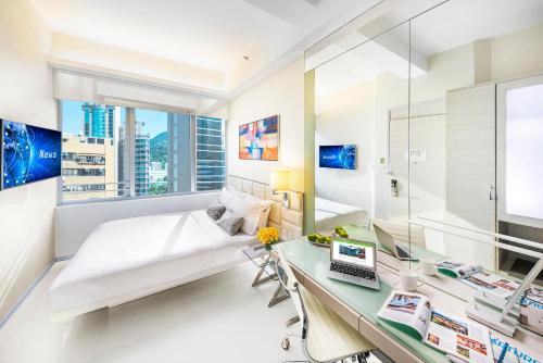 una camera da letto con un letto e una scrivania di iclub Wan Chai Hotel a Hong Kong