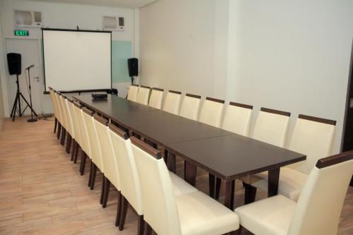 a conference room with a long table and white chairs at Casablanca Suites Near Airport in Legazpi