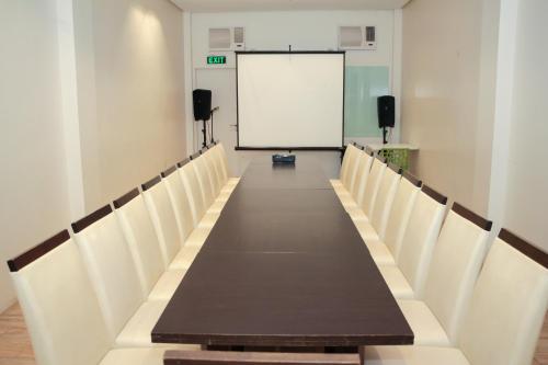 a conference room with a long table and a whiteboard at Casablanca Suites Near Airport in Legazpi