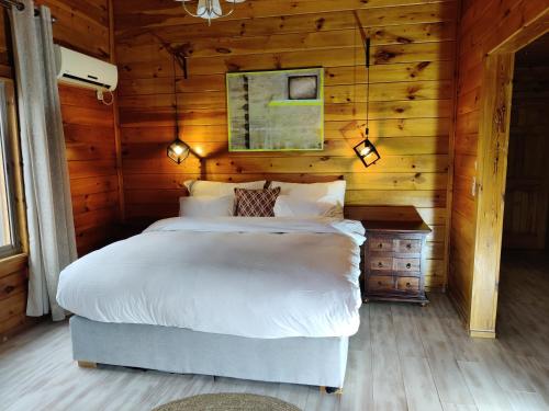 a bedroom with a bed in a wooden cabin at Vibe Naftali Estate in Ramot Naftali