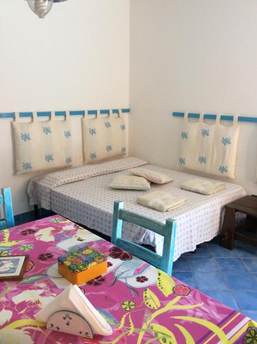 two twin beds in a room with a table at Tiffany Palau in Palau