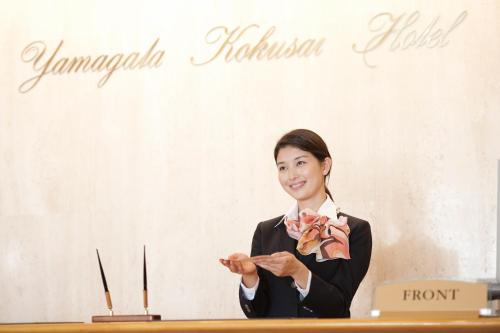 a woman standing next to a table with a sign at Yamagata Kokusai Hotel in Yamagata