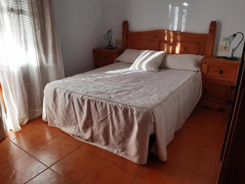 Schlafzimmer mit einem Bett mit einem Kopfteil aus Holz in der Unterkunft Apartamento Fray Eloy de 1 habitacion in Guadalupe