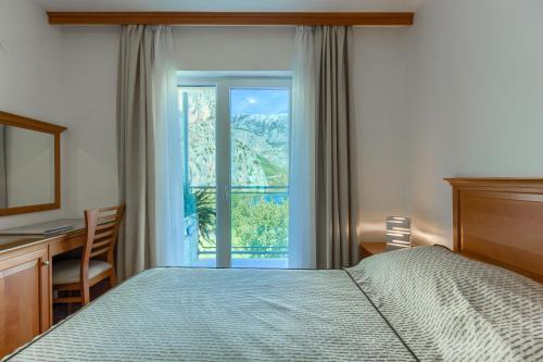 a bedroom with a bed and a window at Hotel Villa Dvor in Omiš