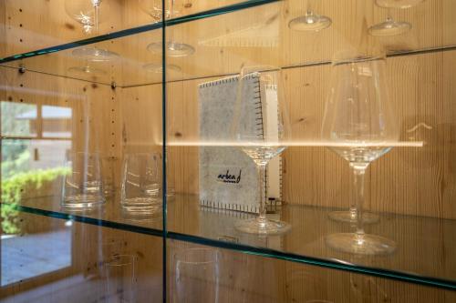 a glass display case with wine glasses in it at Arbea Apartments in Ortisei