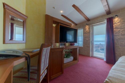a living room with a tv and a table at Hotel Villa Dvor in Omiš