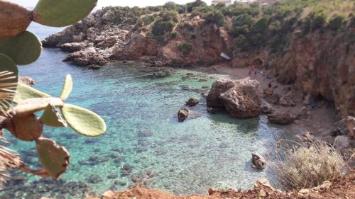 a view of a beach with rocks and water at B&B La mia Isola in Castelluzzo