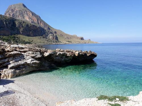 a beach with a bunch of rocks and the water at B&B La mia Isola in Castelluzzo