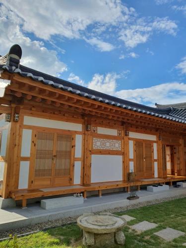 a wooden building with a bench in front of it at SiEunJae in Gyeongju