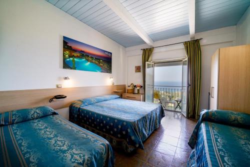 a hotel room with two beds and a balcony at Hotel Orizzonte Blu in Tropea