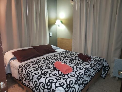 a bedroom with a black and white bed with a red pillow at Inti Mayu in Villa Cura Brochero