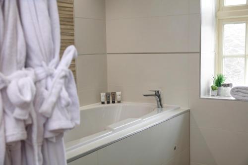 a white bathroom with a tub and a sink at Best Western Premier Doncaster Mount Pleasant Hotel in Doncaster