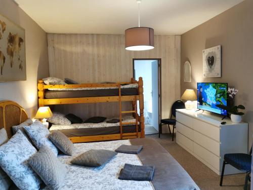 a bedroom with two bunk beds and a couch at Les Cloches de Corneville in Corneville-sur-Risle