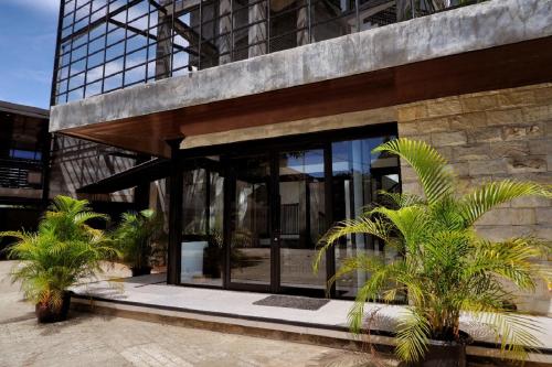 a building with palm trees in front of it at Guest House 555 NKI in Duku