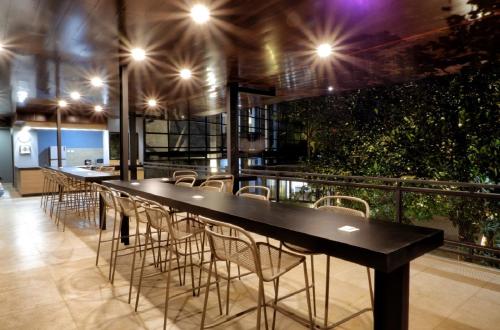 a long table and chairs in a room with plants at Guest House 555 NKI in Duku