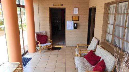 a front porch with two chairs and a door at Premiere Guesthouse in Bloemfontein