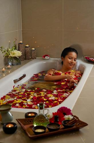 a girl sitting in a bath tub filled with flowers at Royale Chulan Damansara in Petaling Jaya