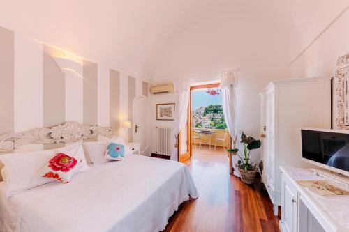 a white bedroom with a bed and a television at Villa Mary Suites in Positano