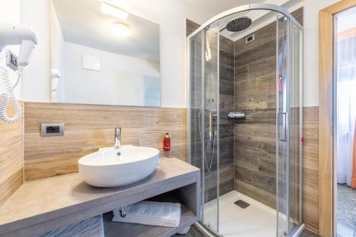 y baño con lavabo y ducha. en Hotel Col di Lana en Canazei