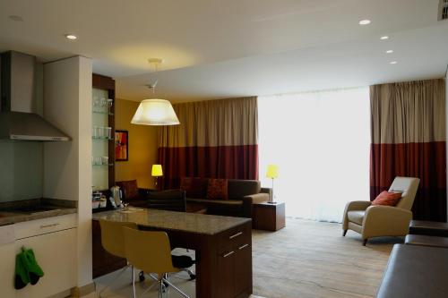 Staybridge Suites Beirut, an IHG Hotel في بيروت: غرفه فندقيه مع مطبخ وصاله