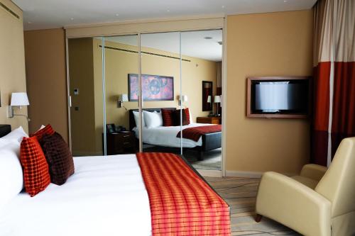 a hotel room with a large bed and a television at Staybridge Suites Beirut, an IHG Hotel in Beirut