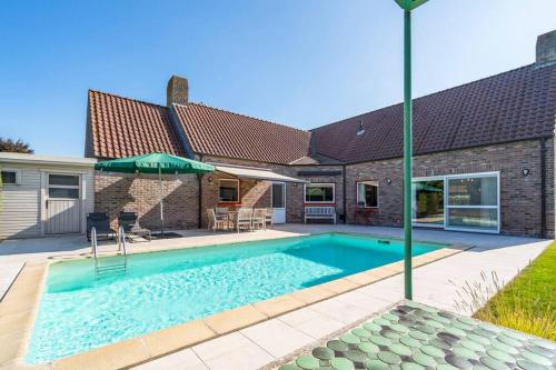 ダンメにあるVilla with heated swimming pool, sauna and gardenの家の裏庭にあるプール