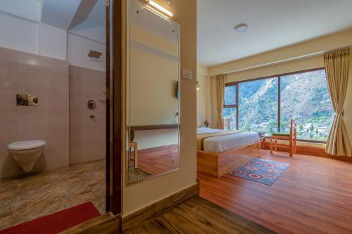 a bedroom with a bed and a bathroom with a window at Magellan's The Golden Bridge in Lachung