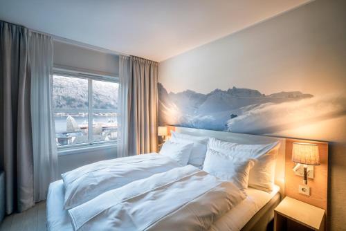 a bedroom with a bed with a painting on the wall at Grand Hotel - by Classic Norway Hotels in Åndalsnes