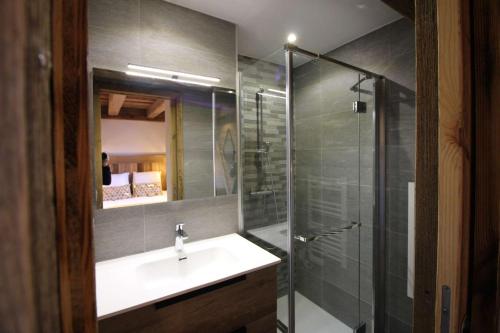 une salle de bain avec un lavabo et une douche en verre dans l'établissement ODYSSEE B203 Vaste appartement en vieux bois sur les pistes, vue panoramique, à La Toussuire