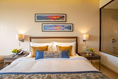 a bedroom with a large bed and two tables at Nanu Resort, Arambol in Arambol