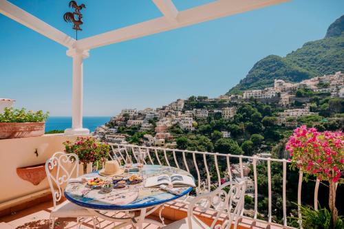 a table and chairs on a balcony with a view of positano at Villa Mary Suites in Positano