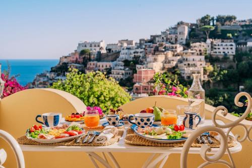 uma mesa com pratos de comida e vista para uma cidade em Villa Mary Suites em Positano