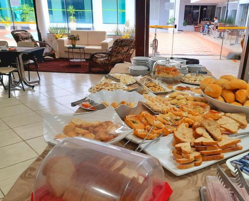 a table filled with lots of different types of food at Biss Inn Hotel in Goiânia
