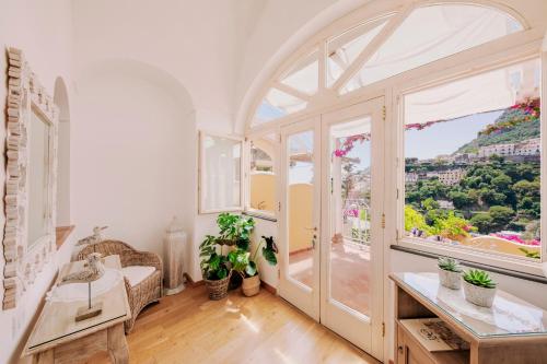 a room with a large window and a table at Villa Mary Suites in Positano