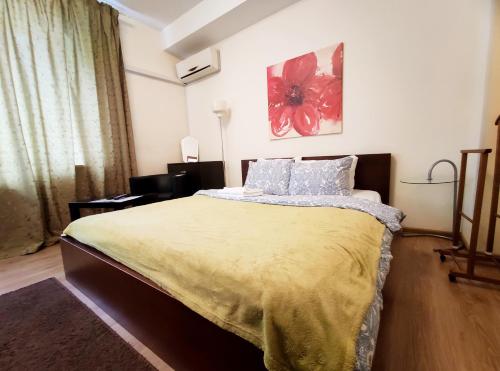 a bedroom with a large bed with a yellow blanket at TVST Apartments Mayakovskaya in Moscow