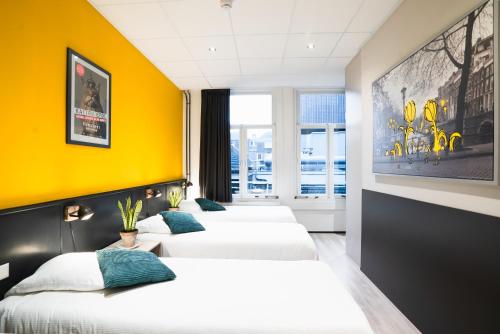 a hotel room with two beds and a balcony at Hotel La Bohème in Amsterdam