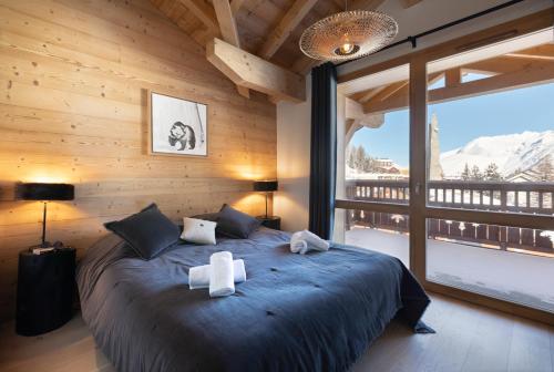 una camera da letto con un grande letto con due asciugamani di TERRESENS - Neige et Soleil a Les Deux Alpes