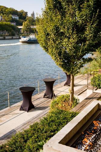two benches and a tree next to the water at Landgoed Kasteel de Hoogenweerth in Maastricht