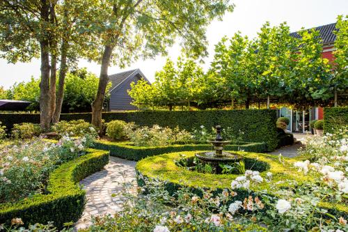 a garden with a fountain in the middle at Landgoed Kasteel de Hoogenweerth in Maastricht