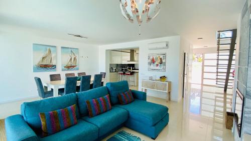 uma sala de estar com um sofá azul e uma cozinha em Albuhera by Check-in Portugal em Albufeira