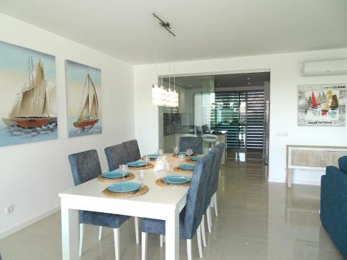 a dining room with a white table and blue chairs at Albuhera by Check-in Portugal in Albufeira