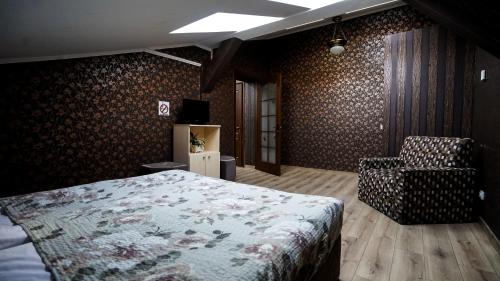 1 dormitorio con 1 cama y 1 silla en Hotel Plazma, en Leópolis