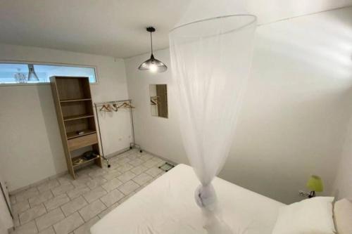 ein Schlafzimmer mit einem Bett mit Vorhang darauf in der Unterkunft Charmant appartement avec piscine in Le Robert